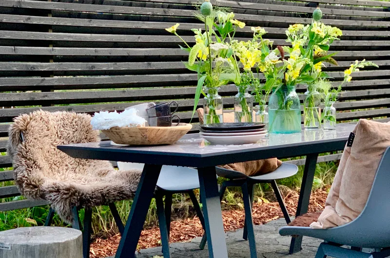 Uudiskohteen moderni piha Vantaalla – ruokailutila kivipatiolla, rima-aita ja toiminnallinen pihasuunnitelma pihasuunnittelijan suunnittelemana.