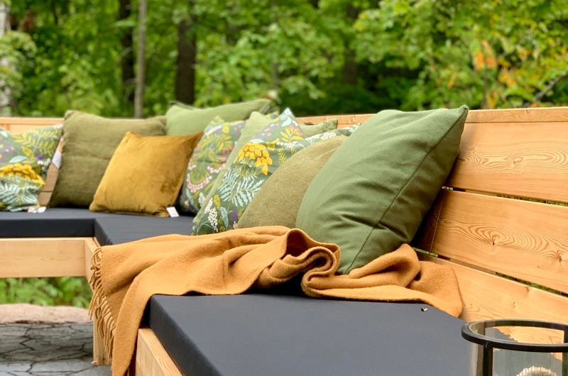 Uudiskohteen metsäpiha Uudellamaalla – ulkosohva, oleskelupiha ja kuntta osana toiminnallista ja modernia pihasuunnitelmaa pihasuunnittelijan suunnittelemana.