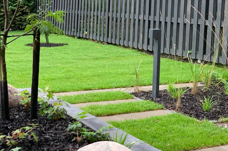 Moderni uudiskohteen pihasuunnitelma Espoossa - Espoossa – askelpolku, pihanurmi ja istutusallas pihasuunnittelijan toteuttamana.