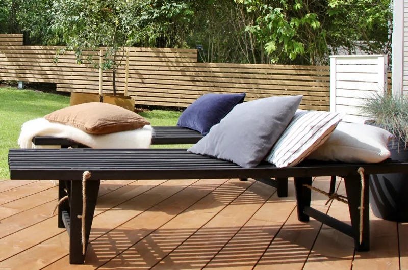 Moderni rivitalon rinnepiha Espoossa – aurinkotuolit, terassi ja rima-aita osana tyylikästä ja toiminnallista pihasuunnitelmaa.